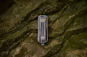 Wood Grain Vaporizer on Mossy Rock Surface