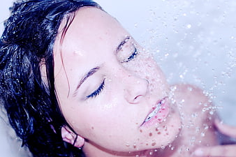 Close-up of woman with wet hair and water droplets on face