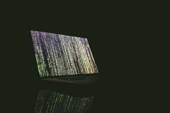 Laptop with Matrix-style code on dark background