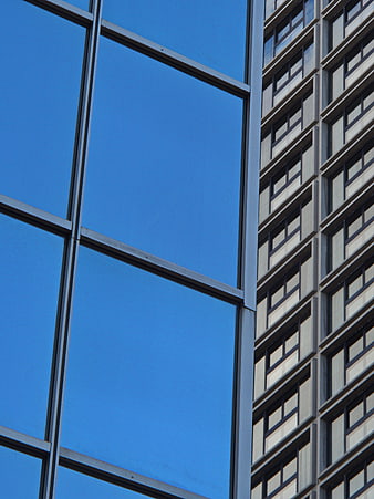 Modern Glass Building Facade with Blue Sky Reflection