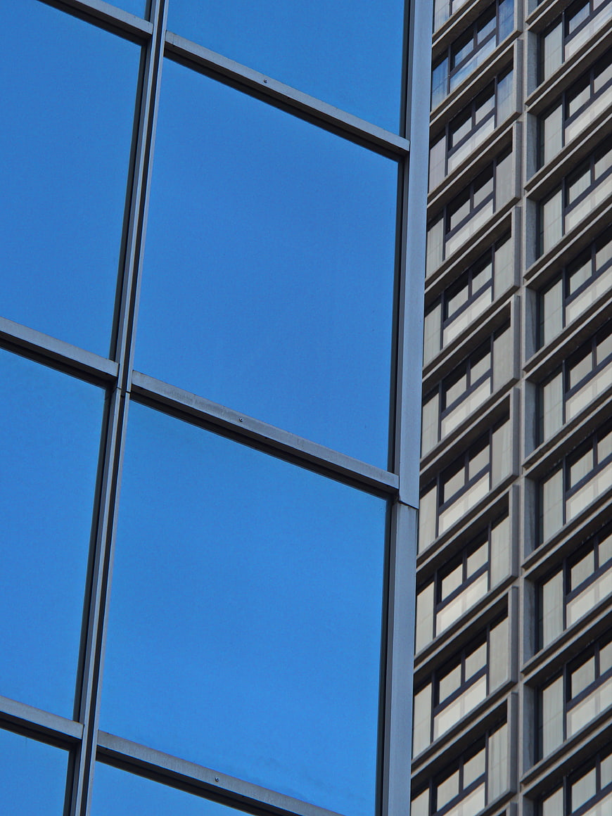 Modern Glass Building Facade with Blue Sky Reflection