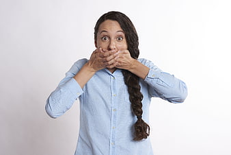 Shocked woman covering mouth with hands in surprise
