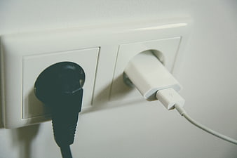 Black and White Power Plugs in Wall Socket