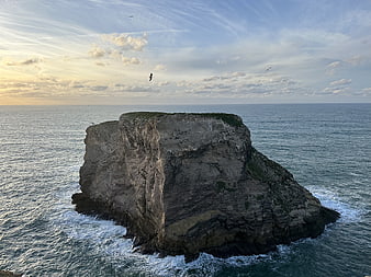 Aerial View of Coastal Rock Formation in Ocean at Sunset