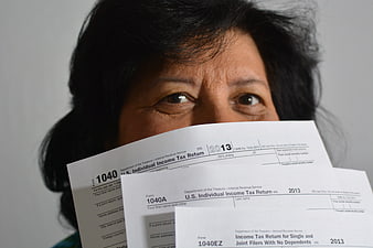 Woman holding 2013 IRS 1040 tax forms