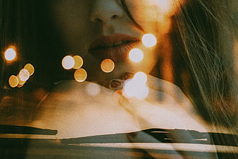 Close-up of woman's lips with warm bokeh lights