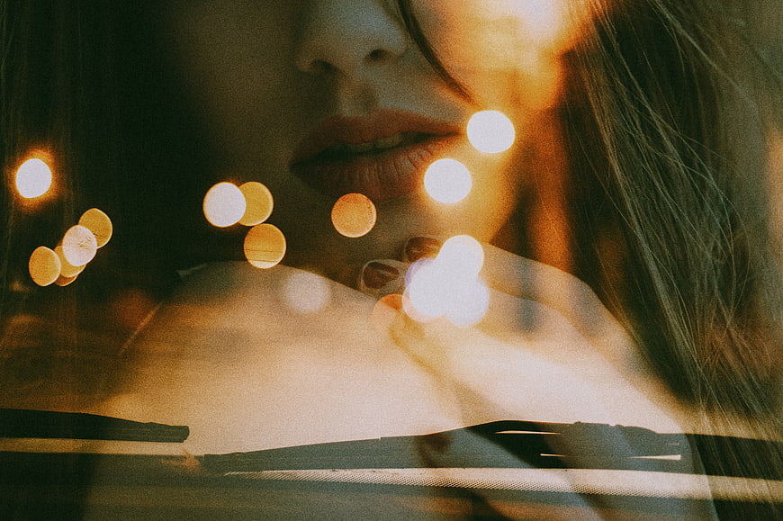Close-up of woman's lips with warm bokeh lights