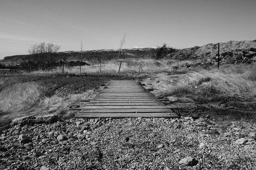 Rustic wooden bridge in black and white rural landscape