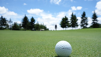 Golf ball on green grass with blurred background