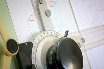 Close-up of drafting tools on architectural blueprint