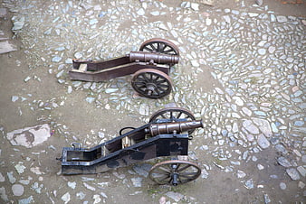 Two antique cannons on cobblestone ground