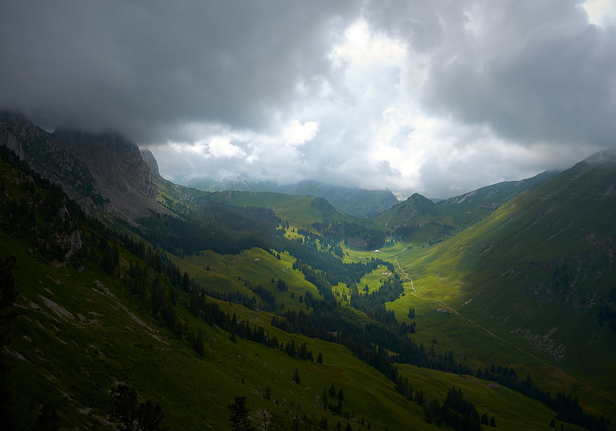 Dramatic Green Mountain Valley with Dark Storm Clouds