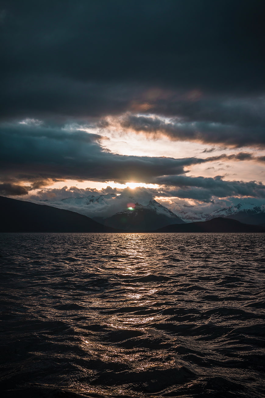 Dramatic Sunset Over Mountain Lake with Golden Reflections