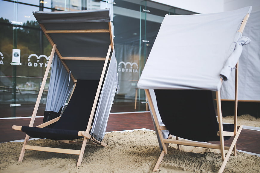 Modern wooden deck chairs on indoor sand display