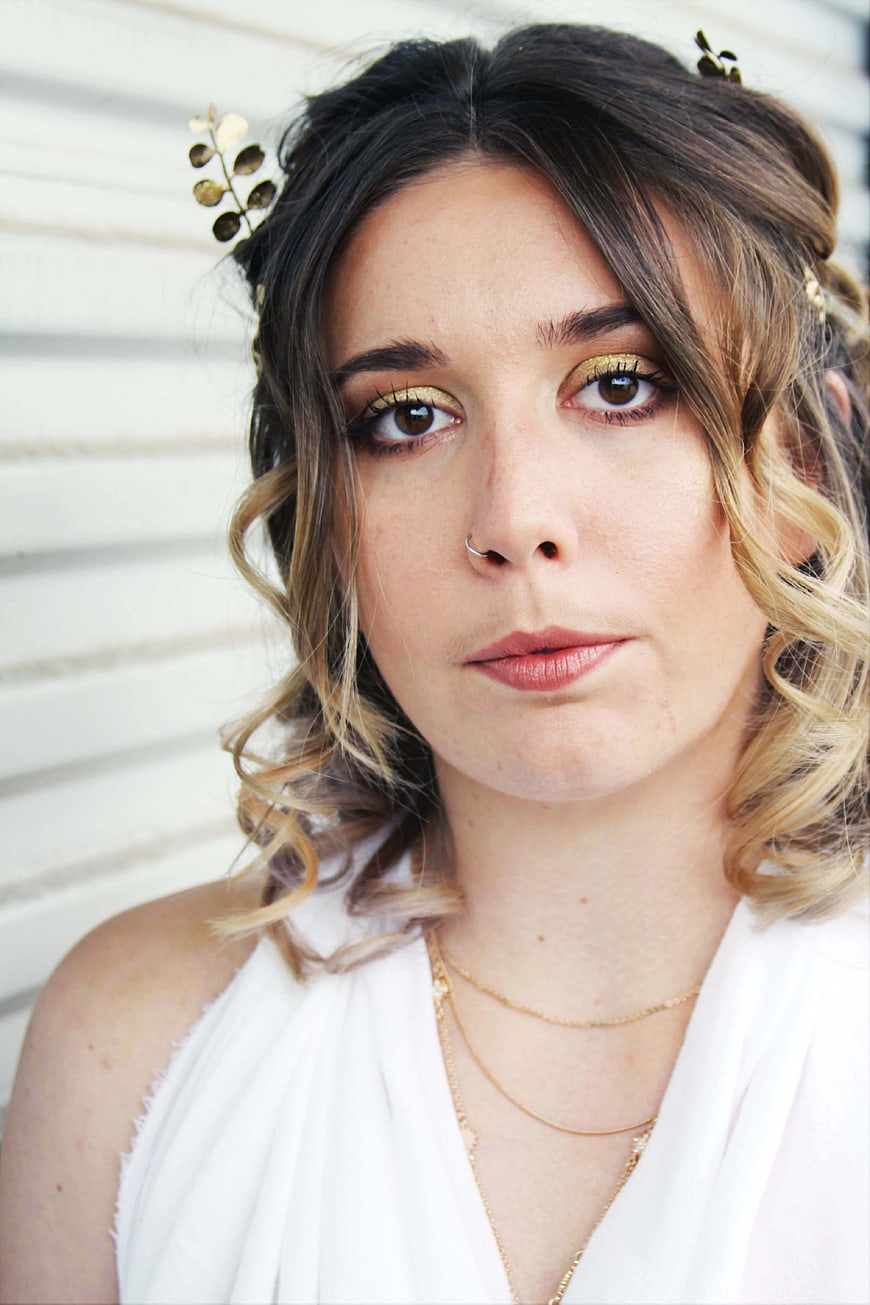 Portrait of woman with gold makeup and floral hair accessories