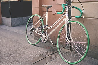 Vintage White Bicycle with Green Tires Parked on Street