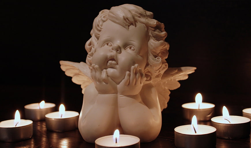White Angel Statue Surrounded by Candles