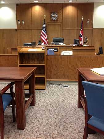 Empty courtroom interior with judge bench and flags