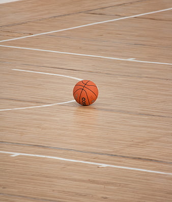 Orange basketball on wooden indoor court floor