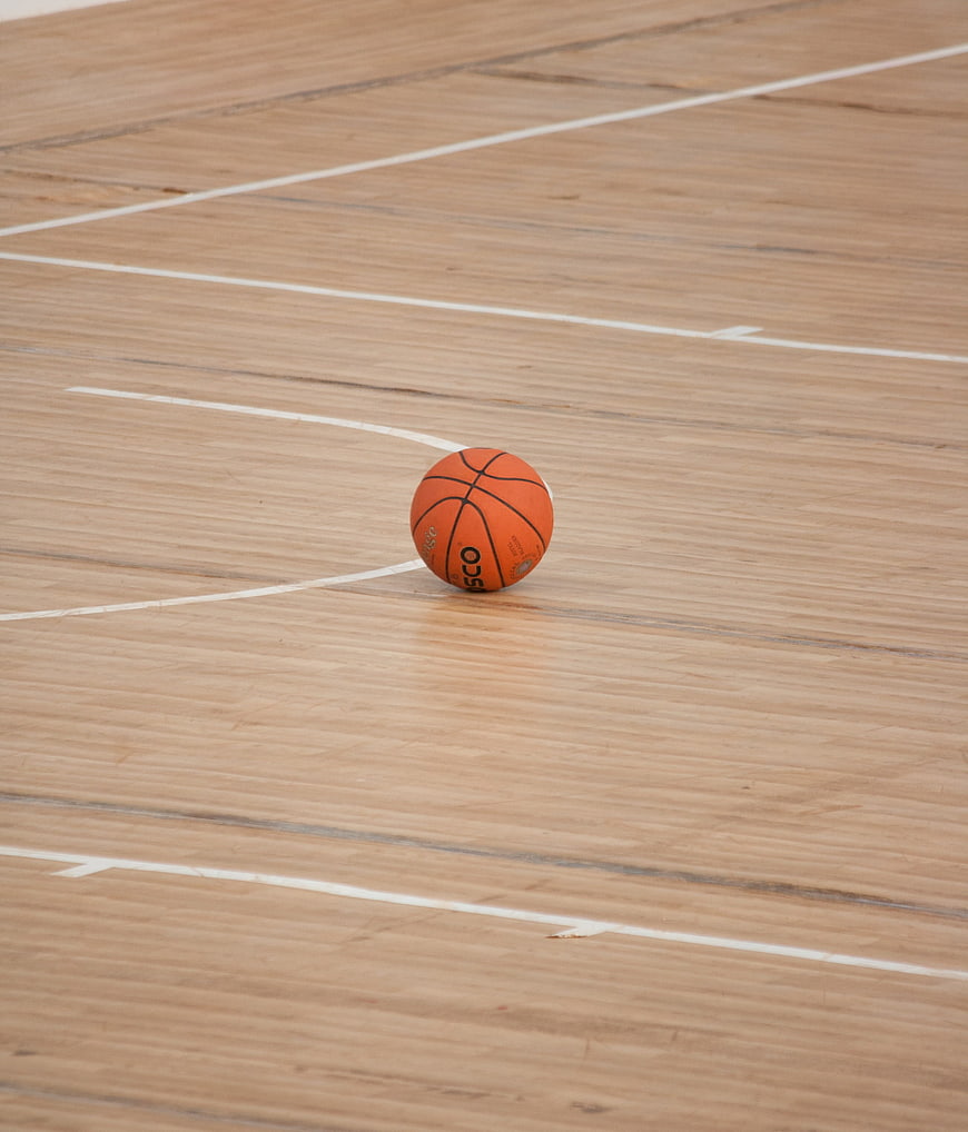 Orange basketball on wooden indoor court floor