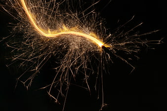 Golden Sparkler Sparks Bursting Against Black Background