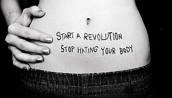 Black and white close-up of a woman's belly with handwritten body positivity message