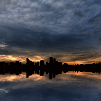 Dramatic city skyline silhouette at sunset with water reflection