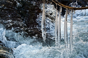 Icicles Hanging Over Flowing Winter Stream