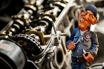 Car Mechanic Figurine Holding Wrench Beside Engine Components