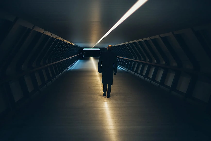 Silhouette of Man Walking in Dark Modern Tunnel