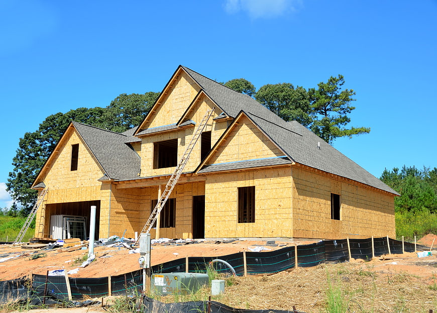 New residential house under construction with wooden sheathing and roof