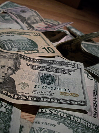 Scattered US Dollar Bills on Wooden Surface