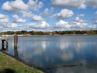 Serene coastal landscape with calm water and blue sky
