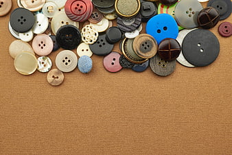 Assorted Sewing Buttons on Brown Fabric Background