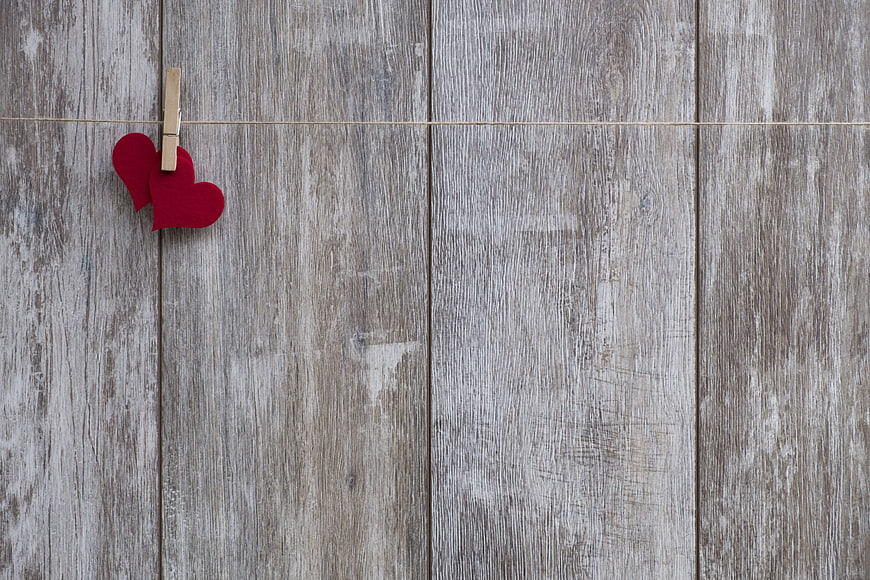 Red Felt Hearts on Clothespin Against Rustic Wood Background
