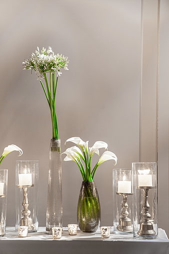Elegant white calla lilies and candles in glass vases