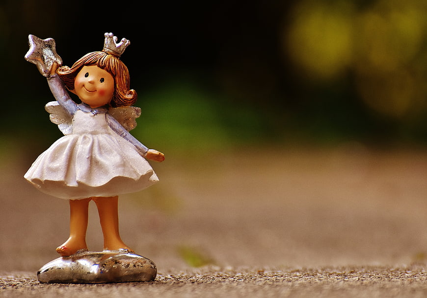 Cute ceramic angel figurine holding a star on a rock