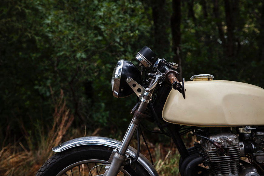 Vintage Cream Motorcycle in Forest Setting