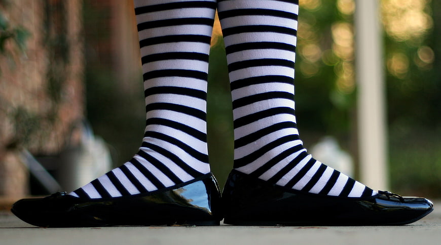 Close-up of black patent shoes and striped tights