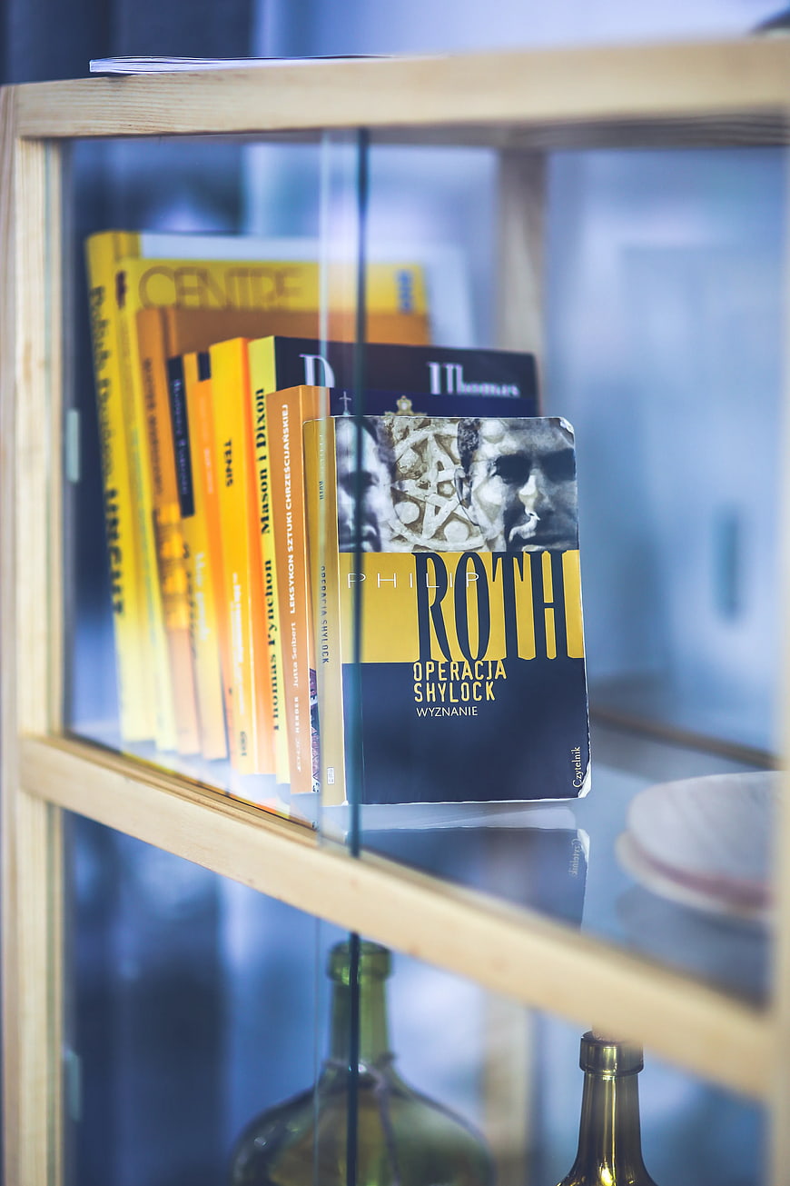 Books on wooden shelf in glass cabinet