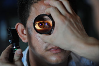 Close-up of eye examination with magnifying lens and light