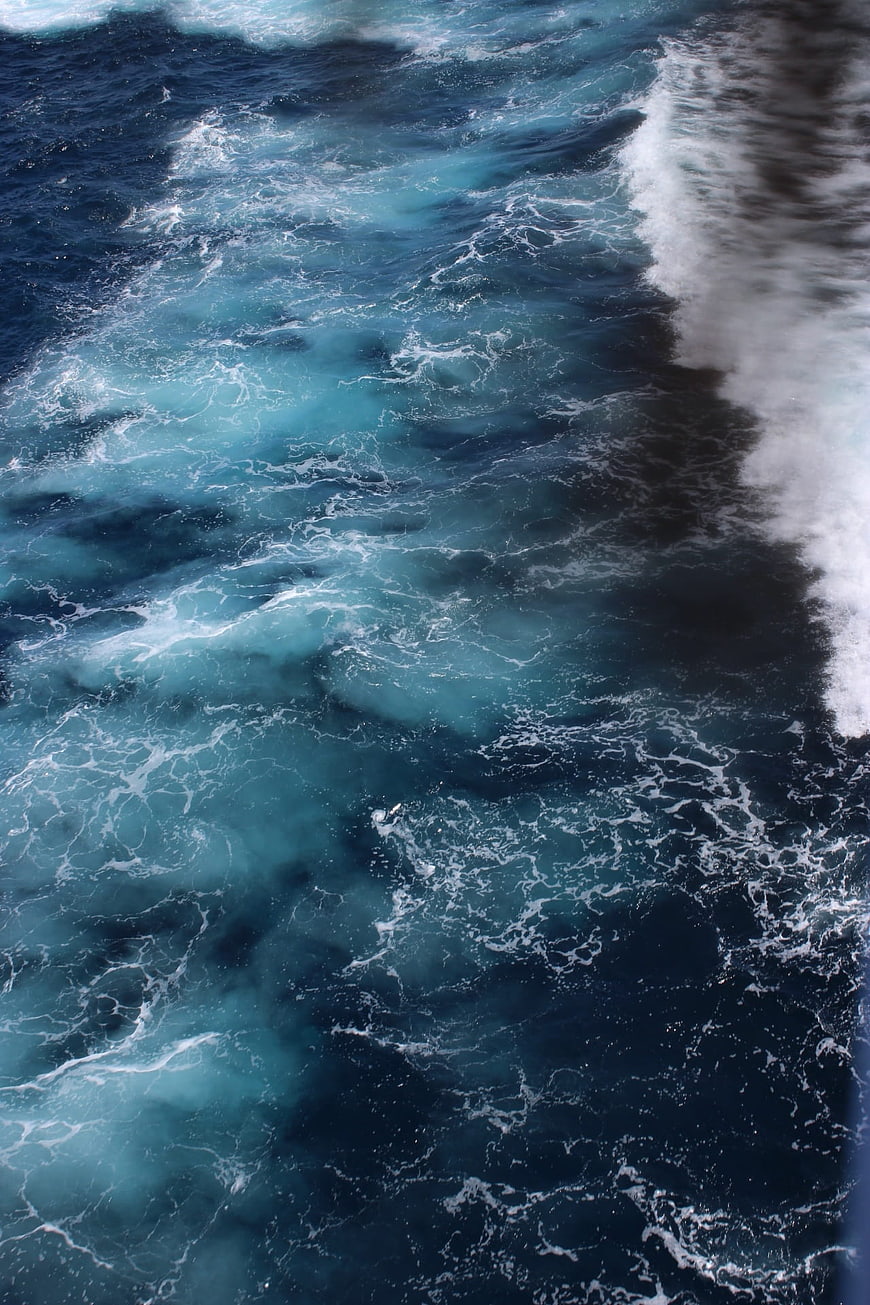 Aerial View of Turbulent Blue Ocean Waves and White Sea Foam
