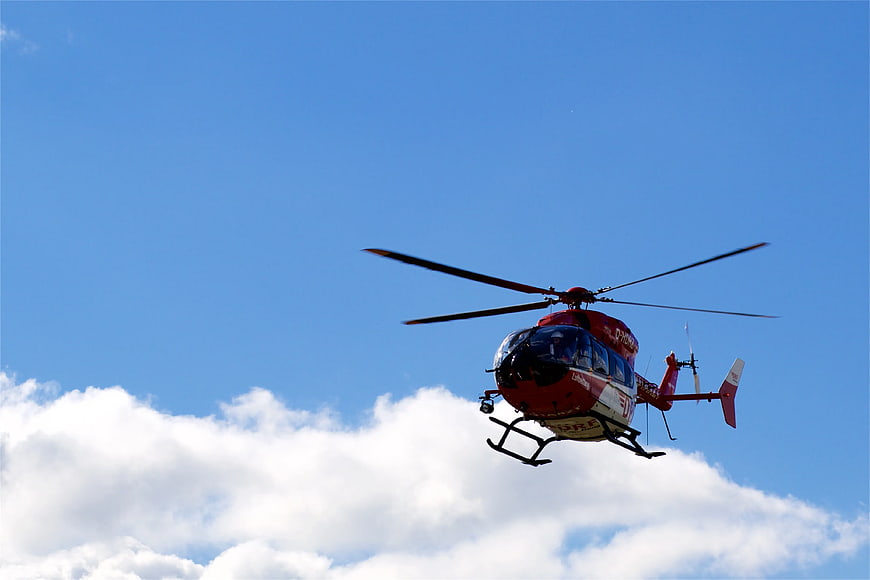 Red and White Helicopter Flying in Blue Sky