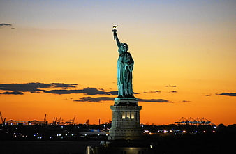 Statue of Liberty Silhouette Against Vibrant Orange Sunset Sky