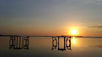 Silhouetted Beach Chairs and Table at Sunset