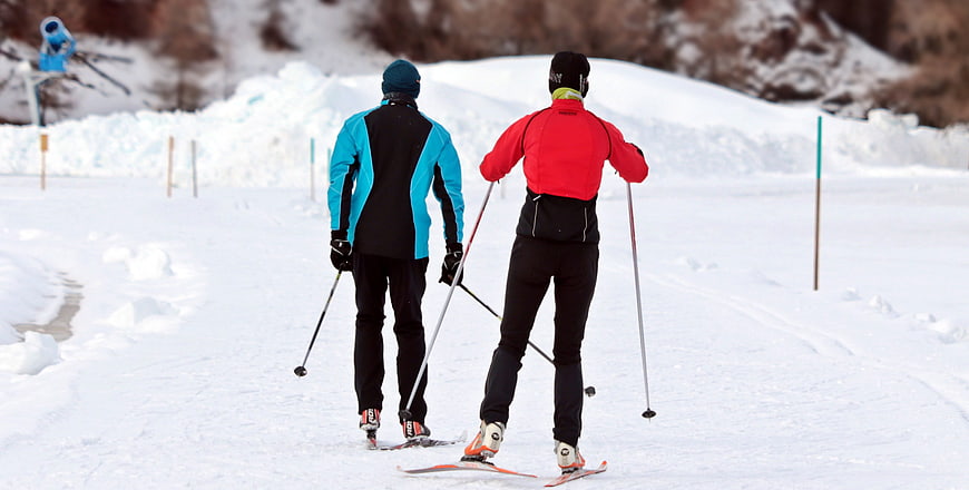 Two Cross-Country Skiers on Snowy Winter Trail