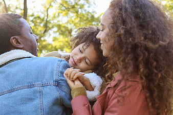 Happy African American Family Hugging Outdoors in Park