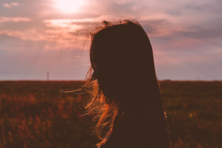 Silhouette of Woman in Field at Sunset