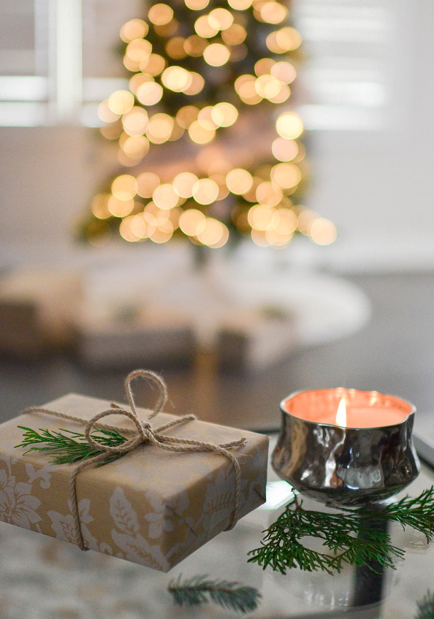 Christmas gift box and candle with bokeh tree background