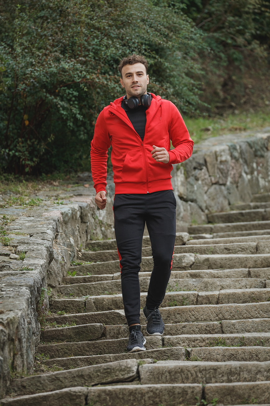 Man Running Up Stone Stairs in Red Hoodie